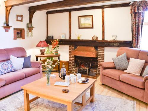 a living room with couches and a fireplace at The Old Workshop in Great Yarmouth