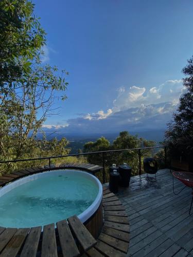 a hot tub on a wooden deck with a view at AKOA GLAMPING Eco-Luxury Hotel in Guarne