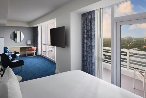 a hotel room with a bed and a large window at Fontainebleau Miami Beach in Miami Beach