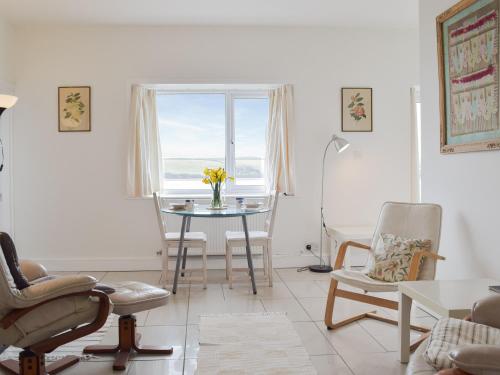 a living room with a table and chairs and a window at Cliff Cottage - Uk43207 in Dale