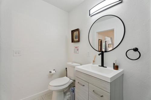 a white bathroom with a sink and a mirror at Uptown Okc Studio Paseo Arts & Bricktown #22a in Oklahoma City