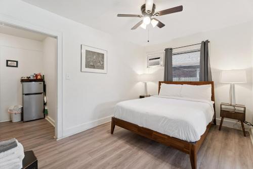 a white bedroom with a bed and a ceiling fan at Uptown Okc Studio Paseo Arts & Bricktown #22a in Oklahoma City