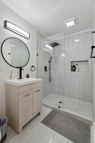 a bathroom with a shower with a sink and a mirror at Uptown Okc Studio Paseo Arts & Bricktown #22a in Oklahoma City