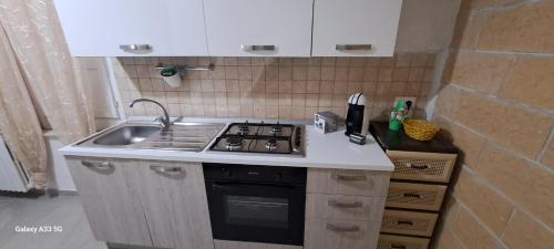 a small kitchen with a stove and a sink at An&Gy house in Tursi