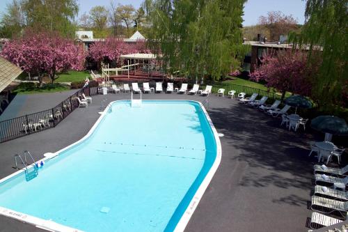 a large swimming pool with chairs and trees at Fireside Inn & Suites Portland in Portland