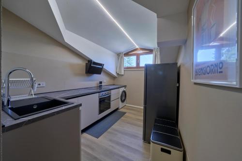 cocina con fregadero y nevera negra en Villa Adige Luxury - M&M Holiday House, en Perugia