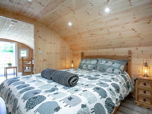 a bedroom with a bed in a wooden cabin at Glamping Pod 1 in Ipplepen