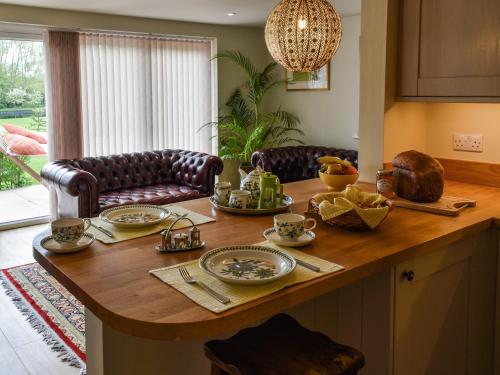 a kitchen with a wooden table with food on it at Swallowtail Lodge in Brundall