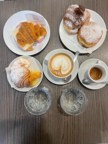 un tavolo con piatti di prodotti da forno e tazze di caffè di B&B Sabò a Bologna