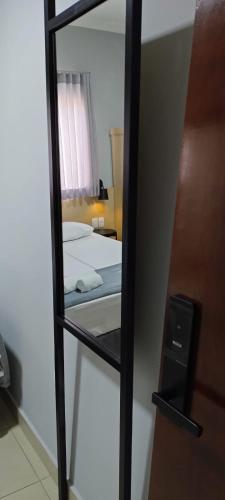 a reflection of a bedroom with a bed in a mirror at Hotel Graal Inn Queluz in Queluz