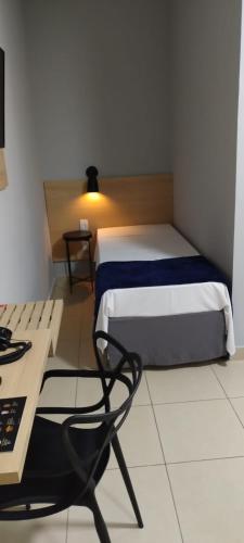 a bedroom with a bed and a table and a chair at Hotel Graal Inn Queluz in Queluz