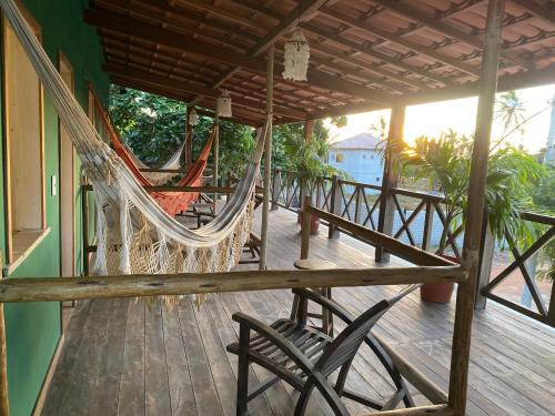 a porch with a hammock and chairs on a deck at Pousada Kalango in Barra Grande