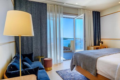 a bedroom with a bed and a couch and a window at Immensely Luxurious Hvar Villa 5 Bedrooms Villa East Eternal Exceptional Sea Views & Private Pool in Hvar