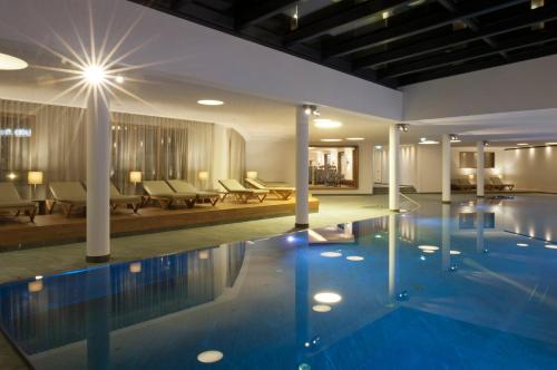 a pool in a hotel with chairs and tables at Kitzbühel Residences in Kitzbühel