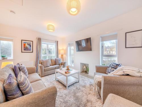 ein Wohnzimmer mit zwei Sofas und einem Fernseher in der Unterkunft Whinstone House in Craster