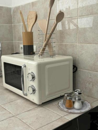 a white microwave sitting on a counter with wooden utensils at Expédit Horizon in Salazie