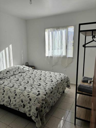 a bedroom with a bed with a black and white comforter at Expédit Horizon in Salazie
