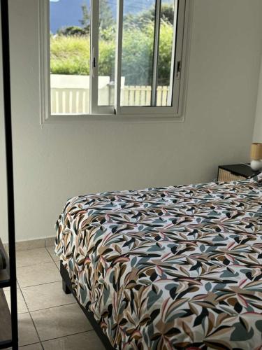 a bedroom with a bed and a window at Expédit Horizon in Salazie