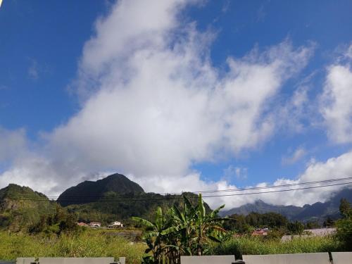 a cloudy blue sky with mountains in the background at Expédit Horizon in Salazie