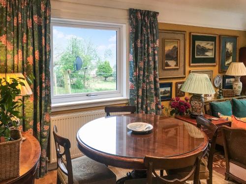 a dining room with a table and a window at An T'abhall in Glencripesdale