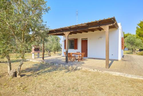 a small white house with a table and chairs at Villetta Lu Jentu in Alezio
