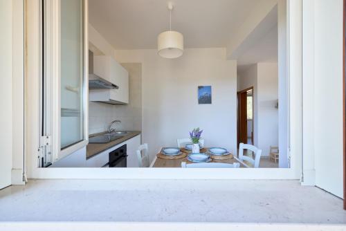 a kitchen and a dining room with a table at Villetta Lu Jentu in Alezio