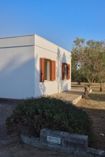a white building with a dog in front of it at Villetta Lu Jentu in Alezio