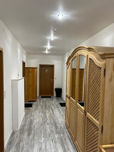 an empty room with wooden cabinets and a hallway at Gasthof Löwen in Pfronten
