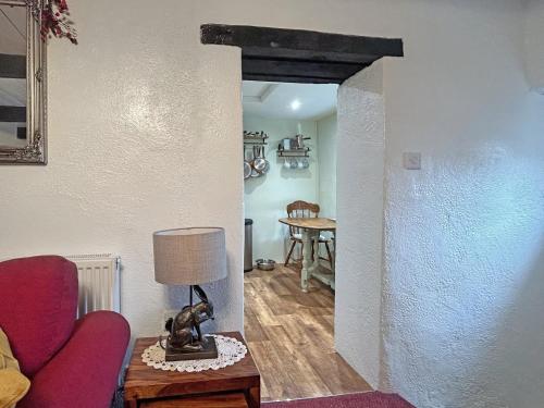 a living room with a red couch and a table at Lyndene Cottage in Moel-tryfan