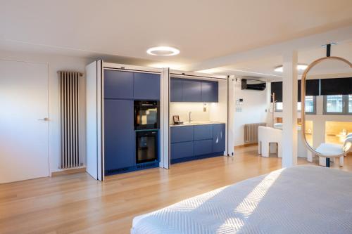 a bedroom with blue cabinets and a kitchen with a table at Apeiron Athena Residences in Athens