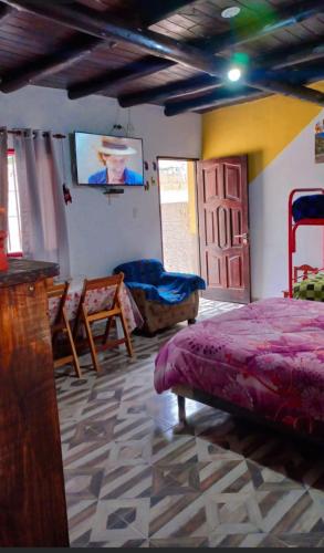 a bedroom with a bed and a flat screen tv at Cabañas virgen de la candelaria in Maimará