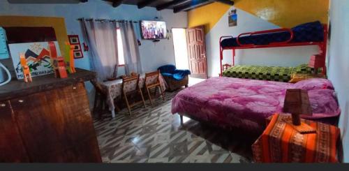 a bedroom with a bed with a purple bedspread at Cabañas virgen de la candelaria in Maimará