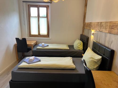 a room with three beds and a table and a window at Gasthof Löwen in Pfronten