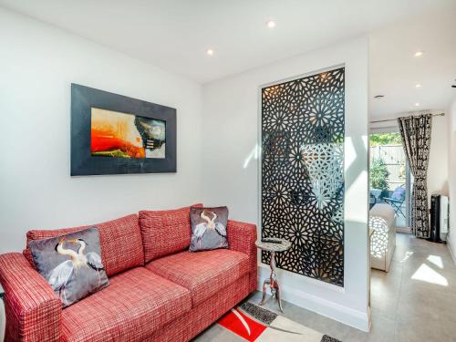 a living room with a red couch and a painting on the wall at Little Heron - Uk40928 in Holdenhurst