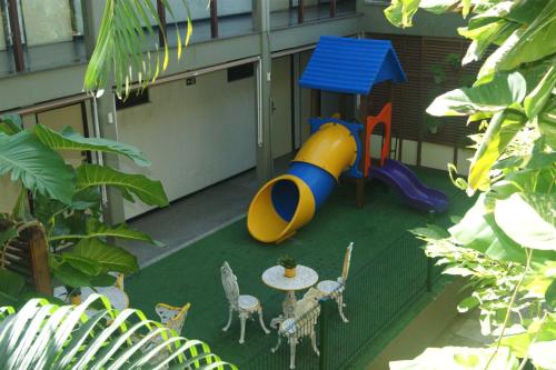 a backyard with a playground with a table and chairs at Amuarama Hotel in Fortaleza