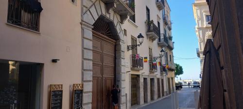 a man standing on a street in front of a building at Alberti Apartments in Trapani