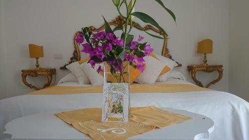 a vase of purple flowers sitting on top of a bed at Villa Yiara in Positano