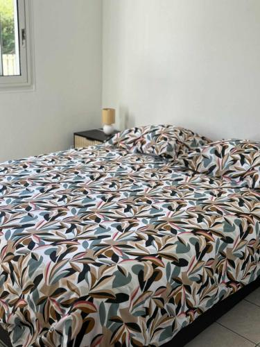 a bedroom with a bed with a colorful comforter at Expédit Horizon in Salazie