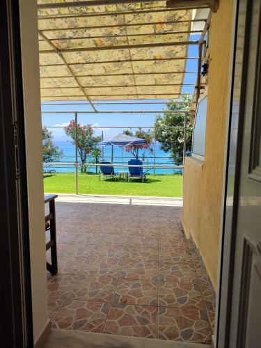an open door to a patio with a view of the ocean at Rosa's Beach Studios in Lourdhata