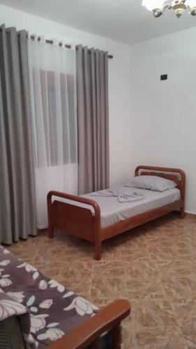 two beds sitting in a room with curtains at Hills Villa in Vlorë