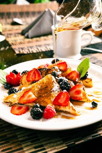 a plate of food with fruit on a table at Esplendor by Wyndham Los Mochis Country Place in Los Mochis