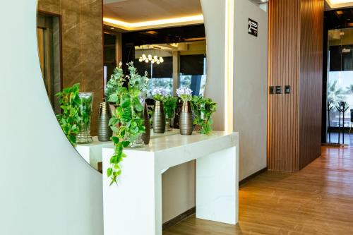 a lobby with a white counter with vases of flowers at Esplendor by Wyndham Los Mochis Country Place in Los Mochis