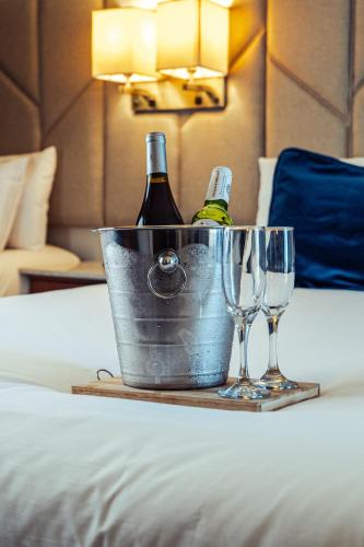 two bottles of champagne and two glasses on a bed at Esplendor by Wyndham Los Mochis Country Place in Los Mochis