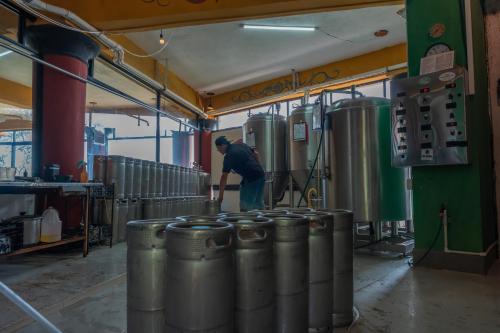 a man standing in a brewery with a bunch of tanks at Lake Arenal Hotel & Brewery in Tilarán