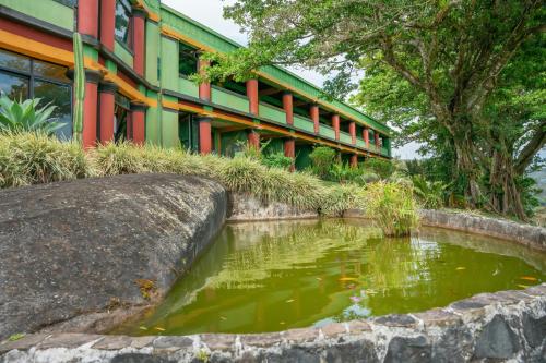a koi pond in front of a building at Lake Arenal Hotel & Brewery in Tilarán