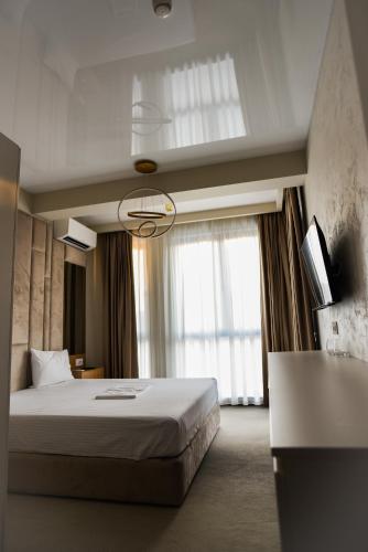 a bedroom with a bed and a large window at Beach Vibe Hotel Mamaia Nord in Mamaia Nord