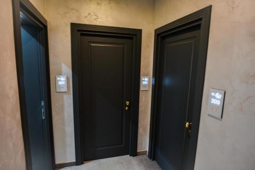 a couple of black doors in a room at Beach Vibe Hotel Mamaia Nord in Mamaia Nord