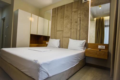 a bedroom with a large bed with white sheets at Beach Vibe Hotel Mamaia Nord in Mamaia Nord