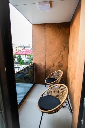 two chairs sitting on a balcony with a view at Beach Vibe Hotel Mamaia Nord in Mamaia Nord