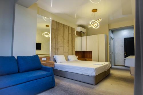 a bedroom with a bed and a blue couch at Beach Vibe Hotel Mamaia Nord in Mamaia Nord
